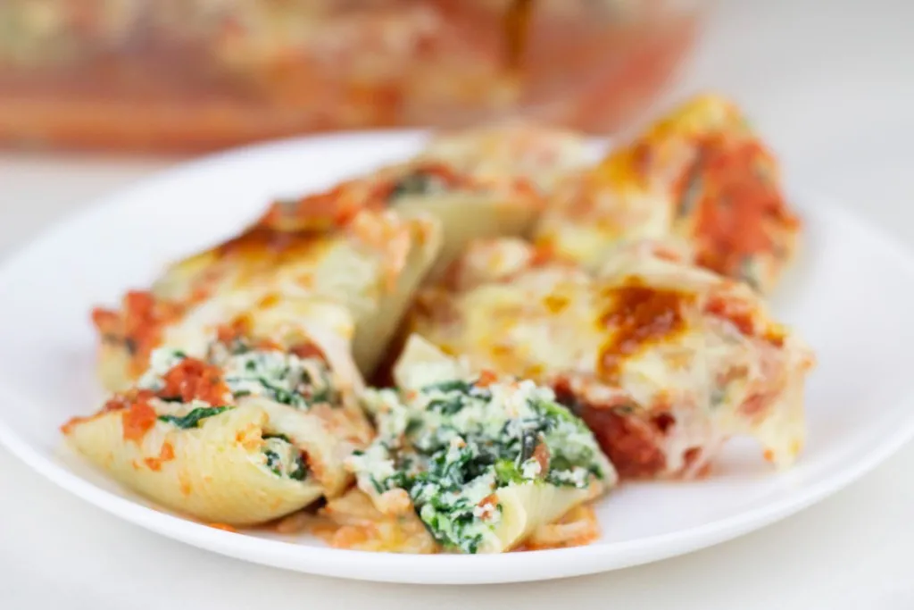 a plate of spinach and ricotta cheese stuffed jumbo shells