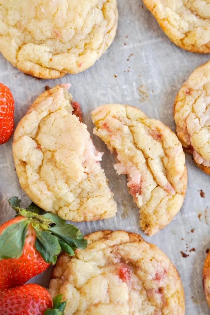 strawberry cookies broken in half with fresh strawberries