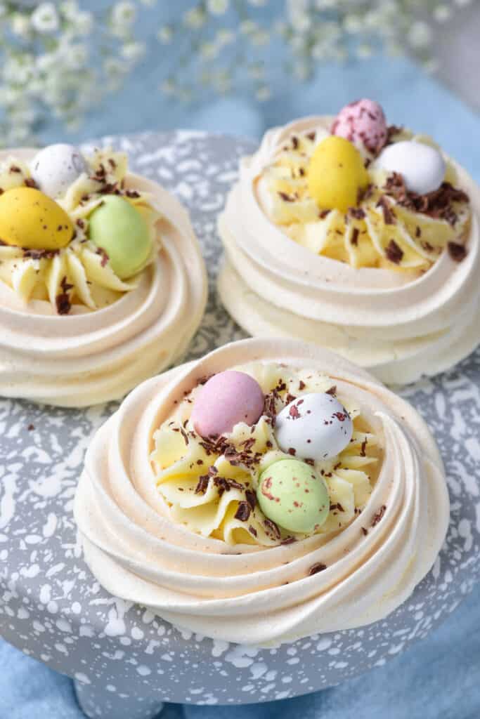 3 mini easter meringue nests and on a blue and white speckled plate
