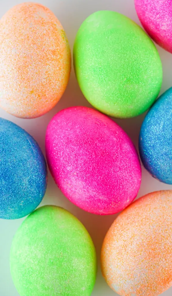 glittered colored eggs laying flat on a background