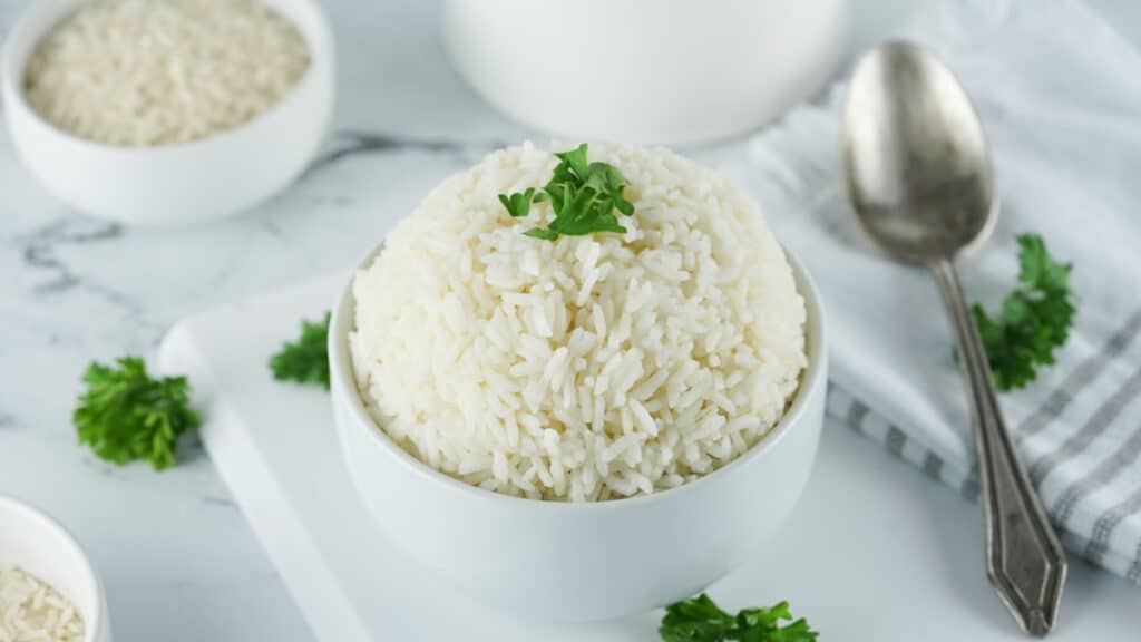 horizontal image of basmati rice made in the instant pot with parsley and a spoon