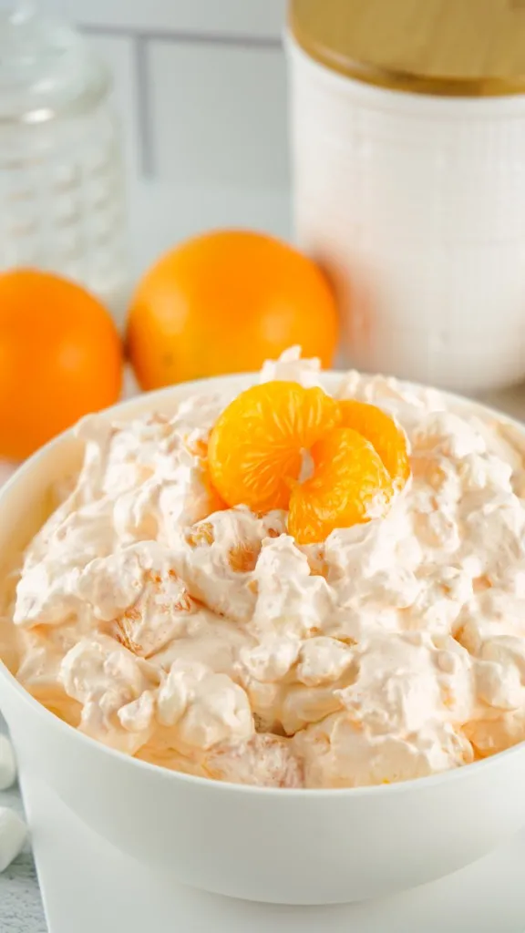 close up shot of mandarin orange segments on an orange fluff salad
