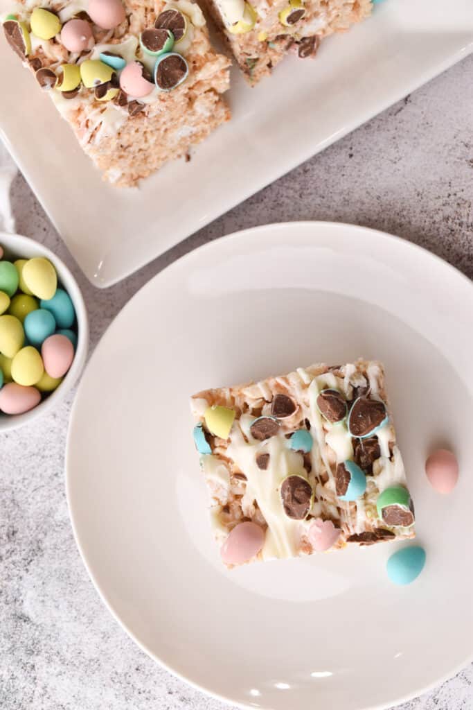 overhead shot of easter rice krispies treats with melted white chocolate drizzled on top with mini cadbury eggs