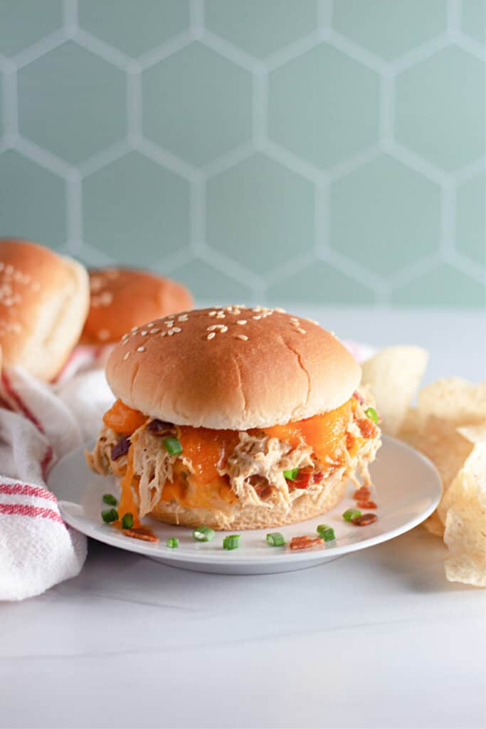 crack chicken sandwich on a white marble top with a light blue hexagon background
