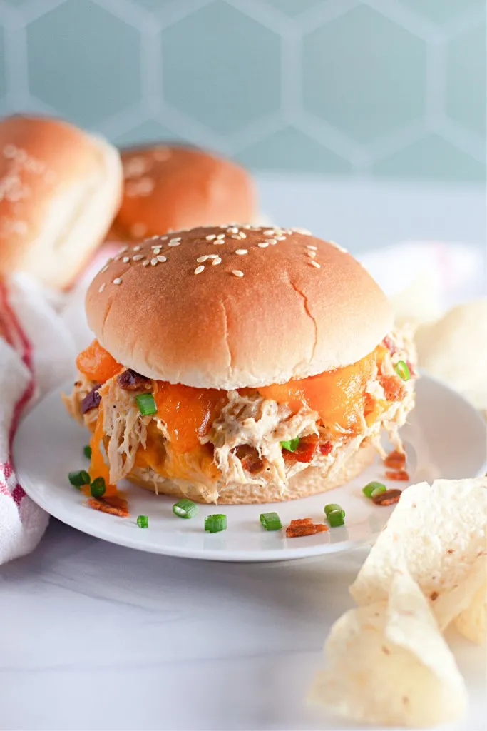 crack chicken sandwich garnished with crumbled bacon and diced green onions