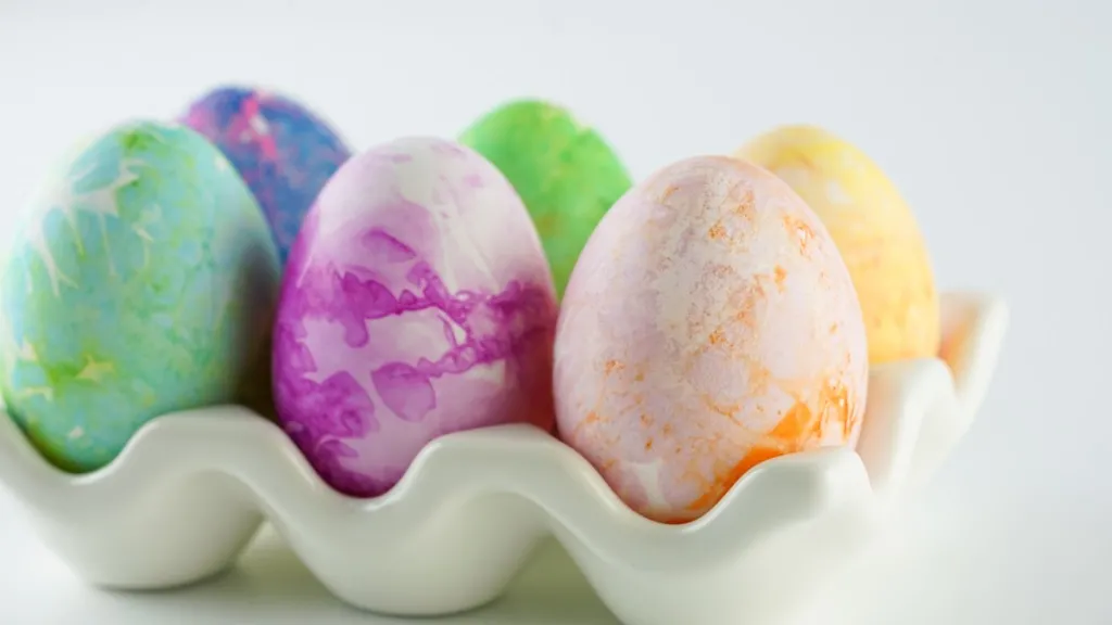 side view of dyed easter eggs in a ceramic egg holder