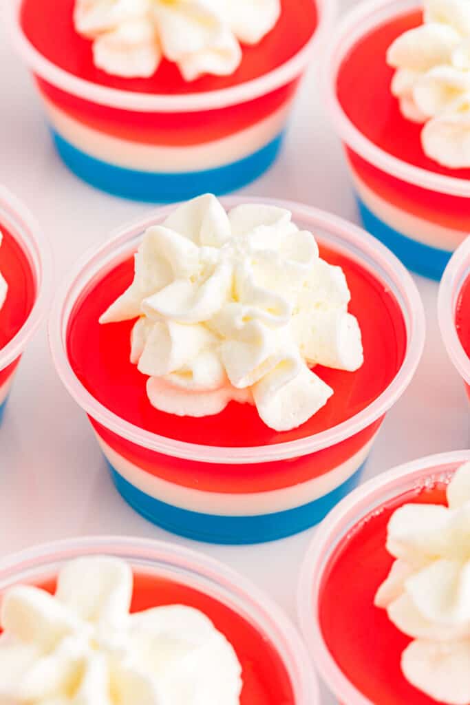 multiple 4th of july jello shots with whipped cream