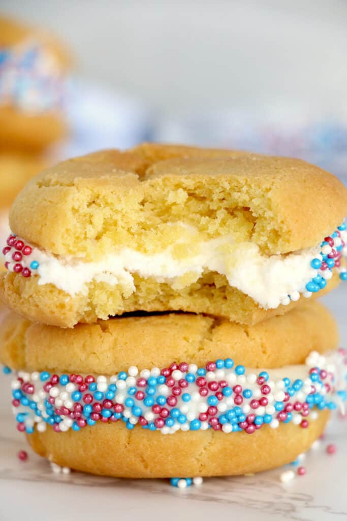 Stacked air fryer sugar cookie whoopie pies with bite taken from the top cookie.