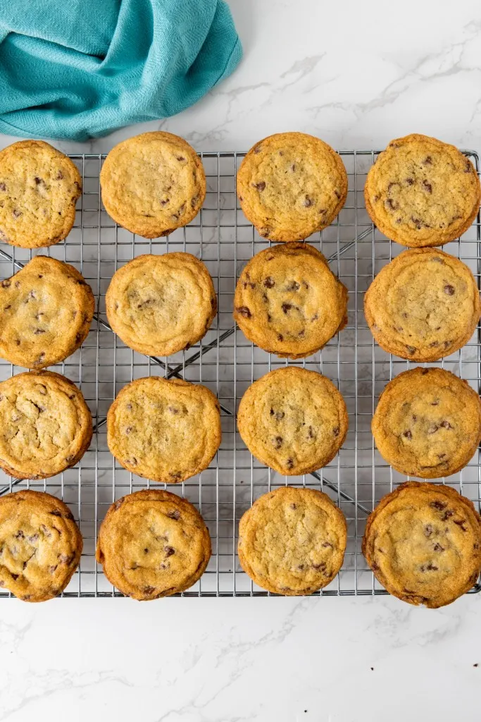 Wire cooling rack with freshly baked mini chocolate chip cookies.
