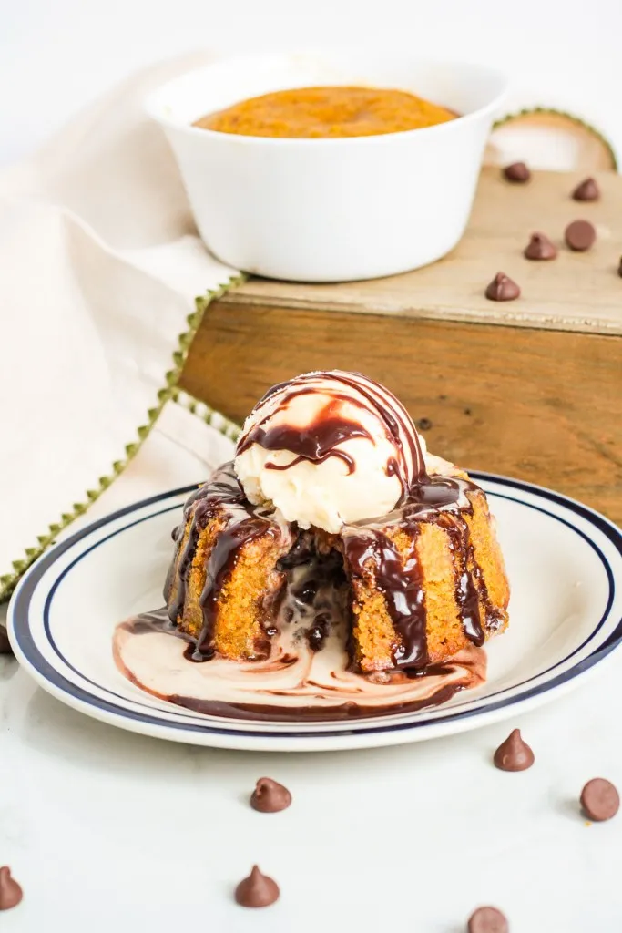 Pumpkin lava cake with melted chocolate ganache oozing out and a scoop of vanilla ice cream on top. 