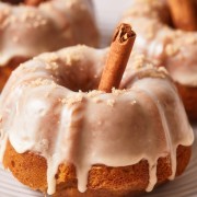 Three mini pumpkin bundt cakes on a white plate.