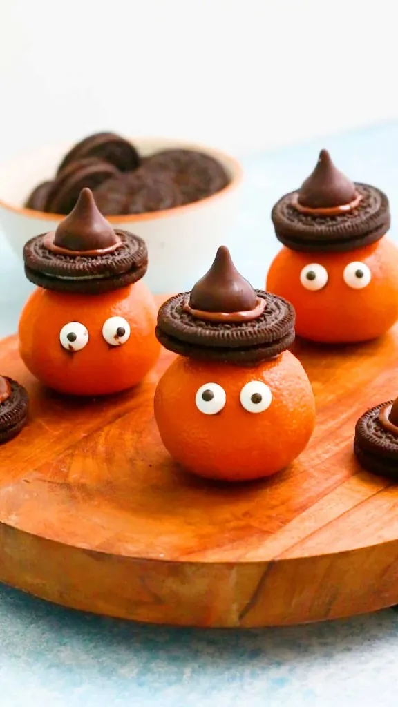 clementine oranges decorated with witches hats with oreo cookies and hershey kisses
