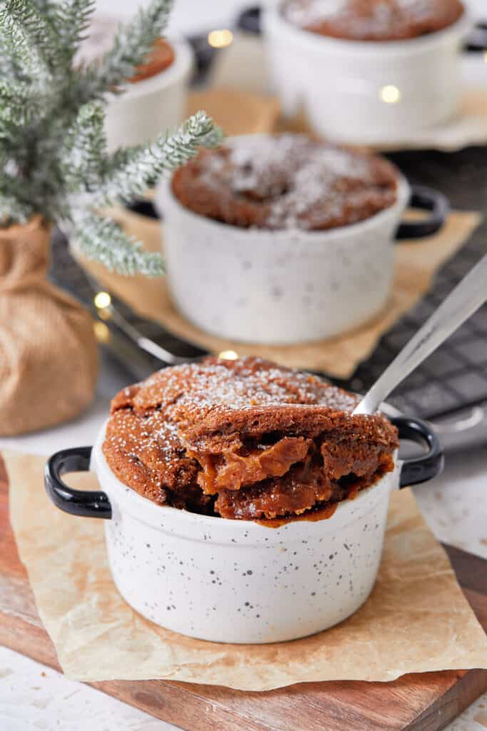 Gingerbread pudding cakes on decorative napkins with Christmas decoration in the background.