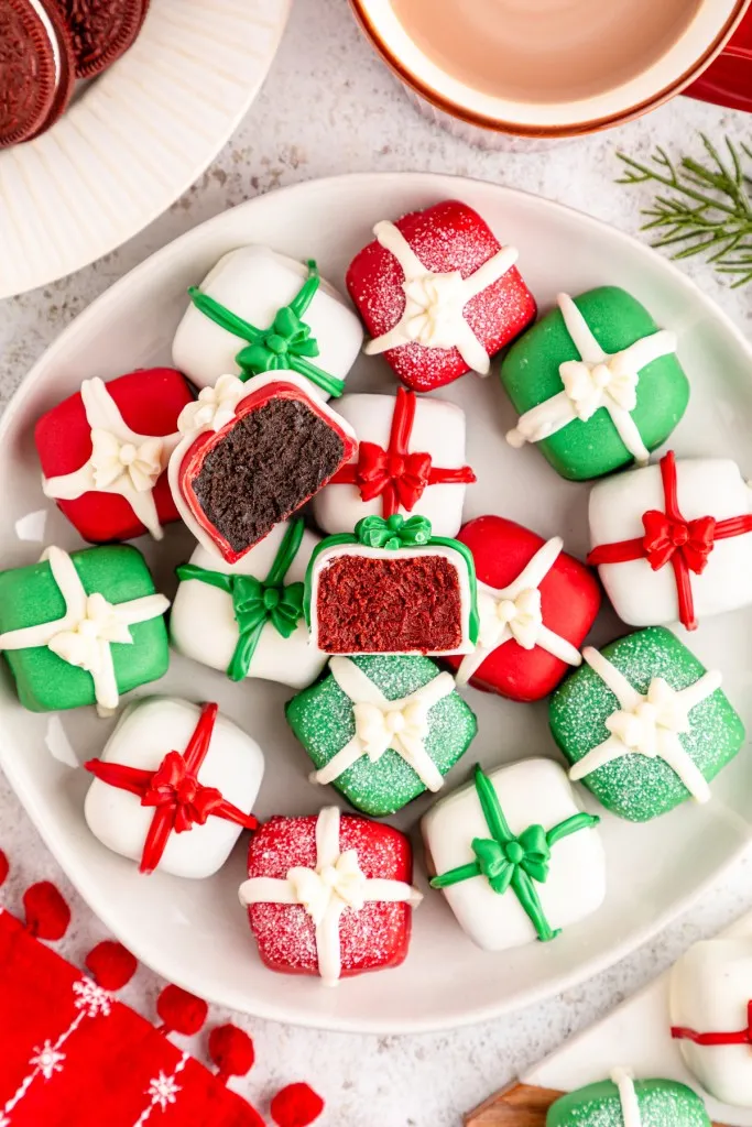 Christmas Oreo presents on a white plate with a bite removed from one.