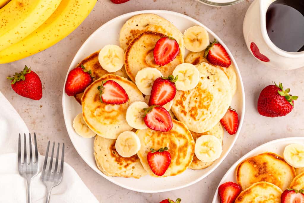 horizontal overhead shot of mini pancakessliced bananas and strawberries