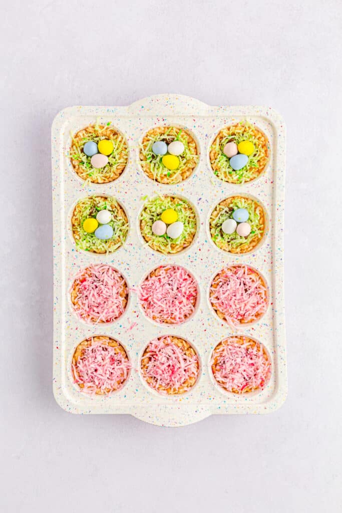 Mini muffin tray with assembled Easter Rice Krispies Nests, topped with mini Cadbury Easter eggs. 