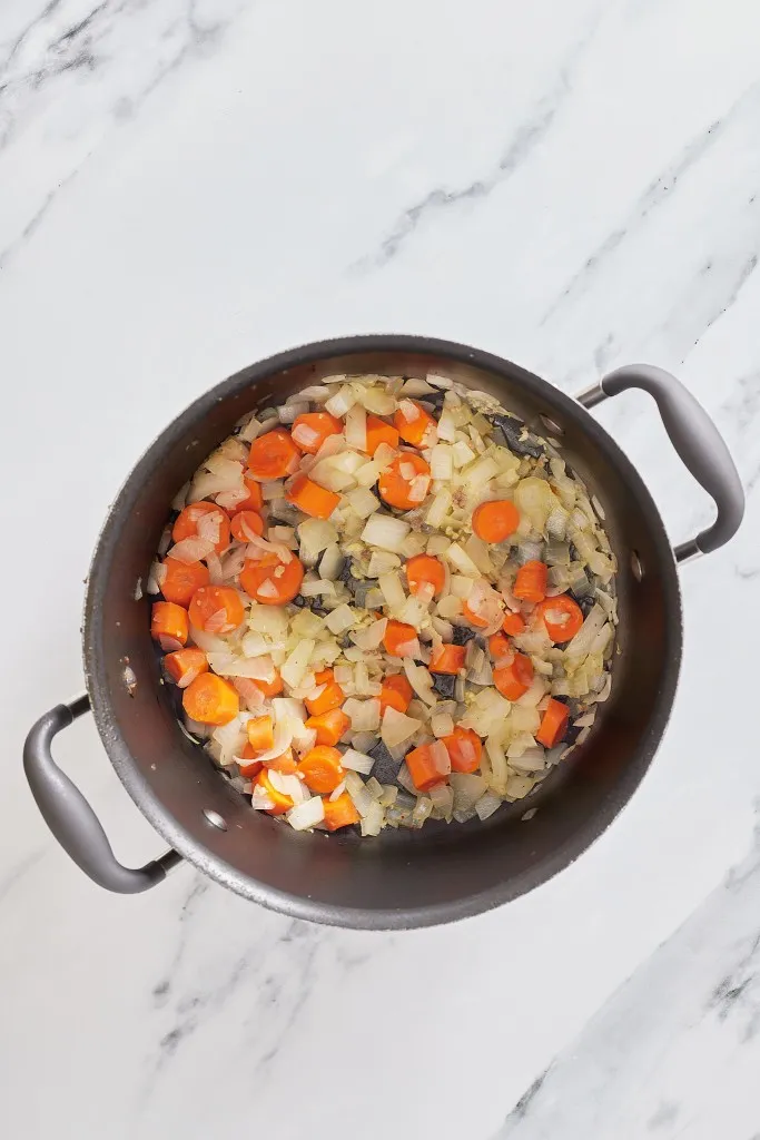 Overhead view of chopped onions and carrots.