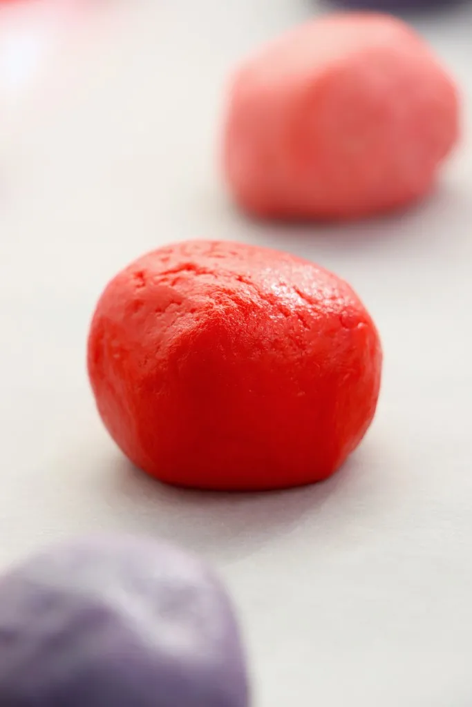 Valentine's whoopie pie dough balls on a baking sheet.