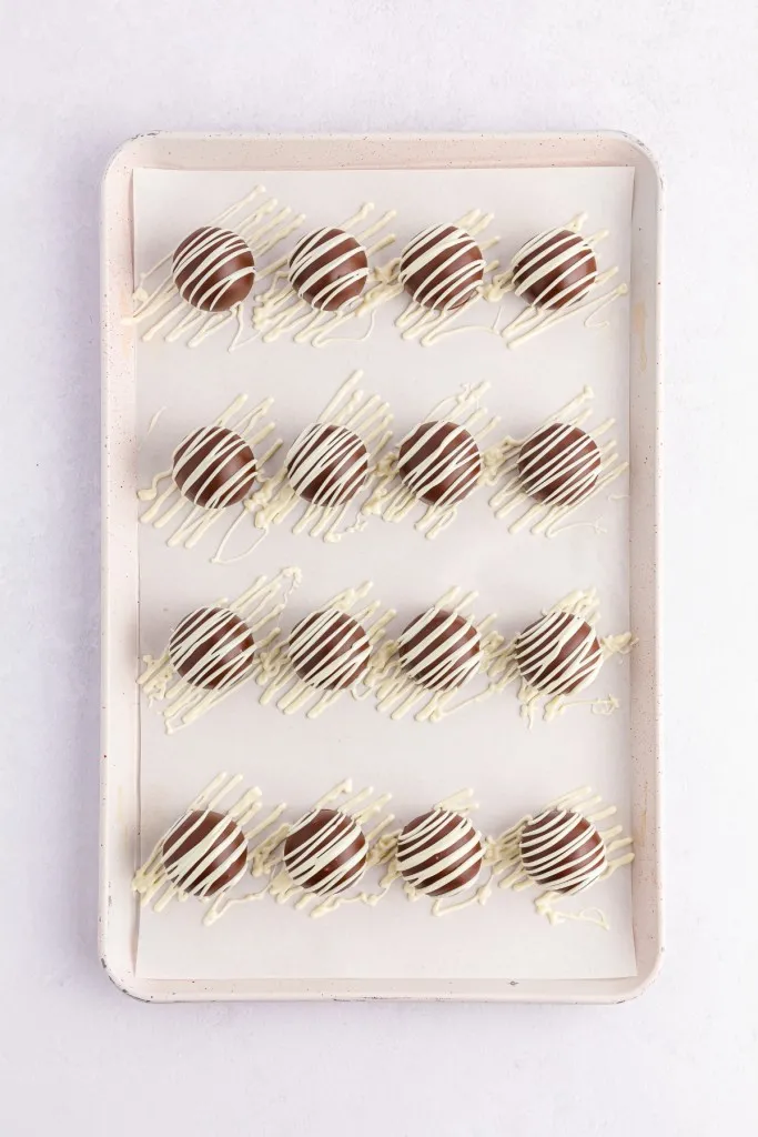 Tray of brownie balls with drizzled melted white chocolate. 