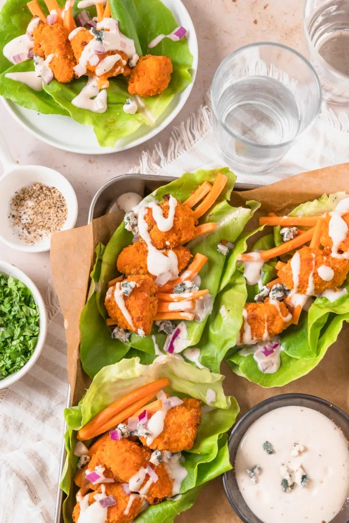 Buffalo Chicken Lettuce Wraps on a serving tray with dressing. 