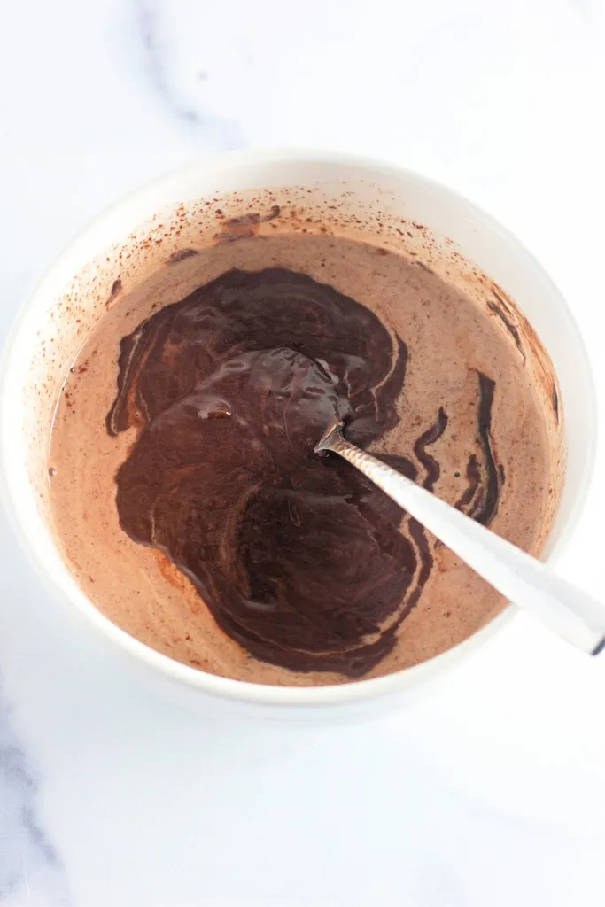 Mixing bowl with heated cream and melted chocolate chips.