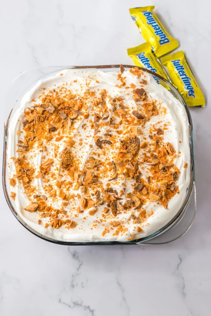 Fully assembled Butterfinger lush dessert, topped with chopped Butterfingers.