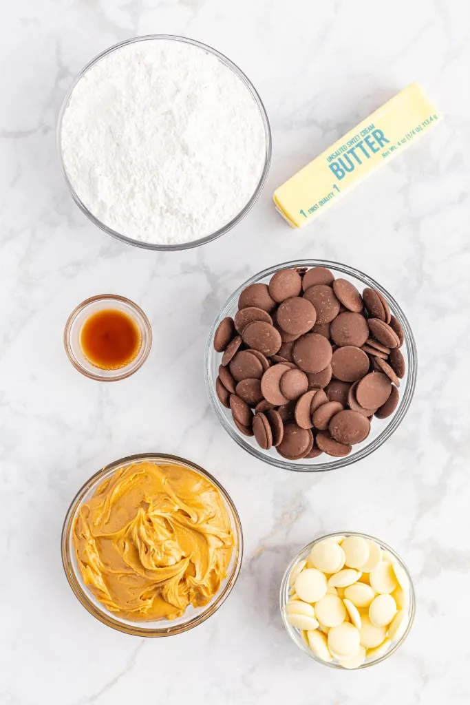 Ingredients for chocolate covered peanut butter balls on a marble countertop.