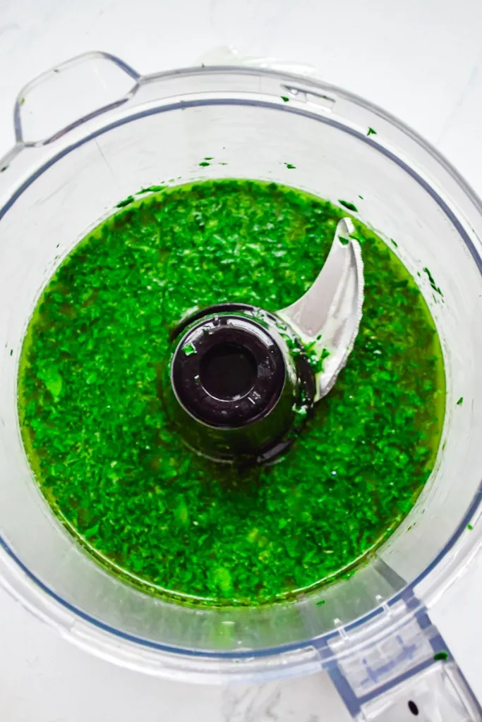 Close up of freshly made gremolata in a food processor.