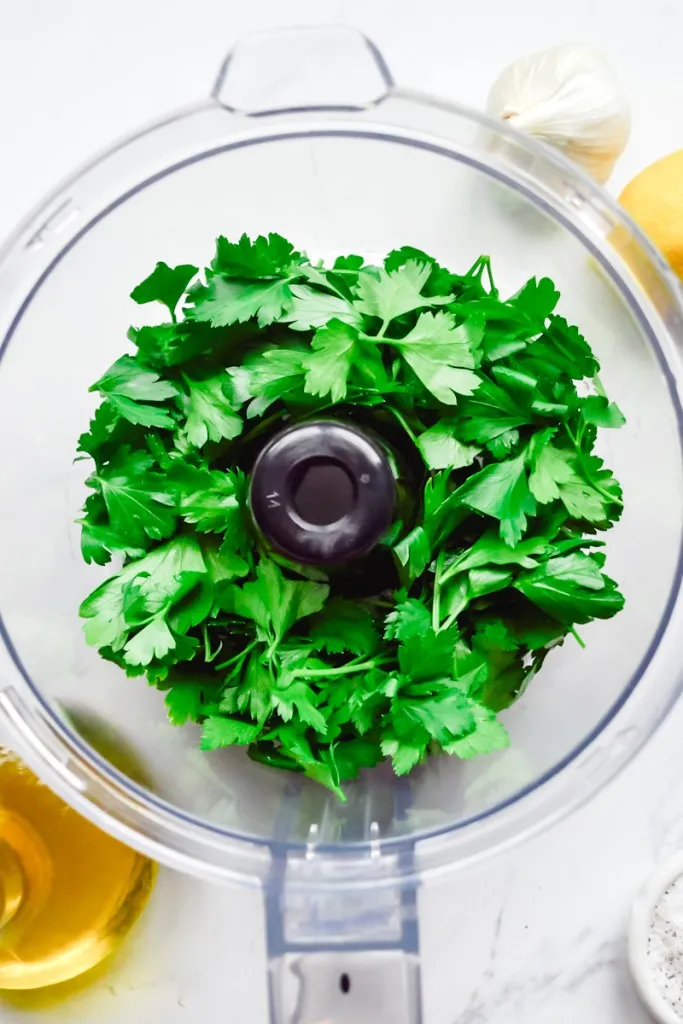 Flat-leaf parsley added to a food processor to make gremolata.