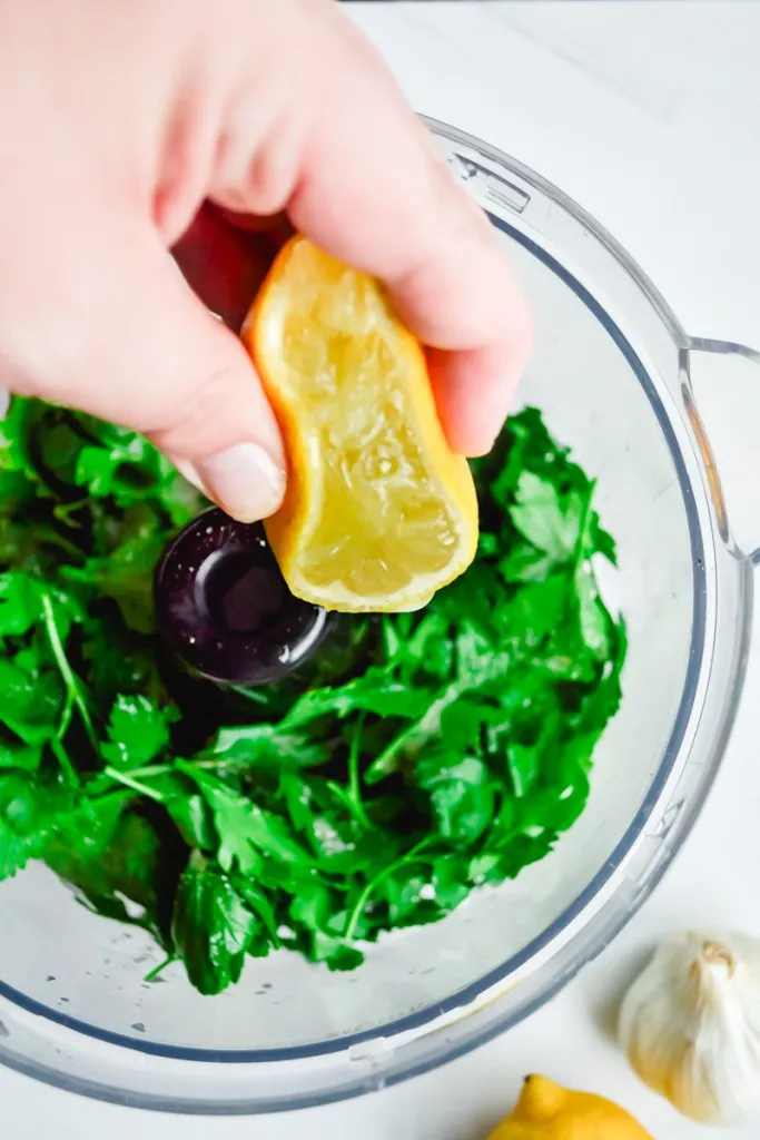 Lemon juice squeezed from half of a lemon into the food processor with the parsley.
