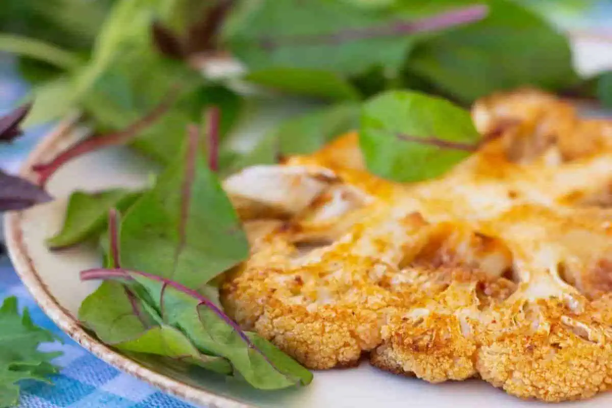 A cauliflower steak on a plate.