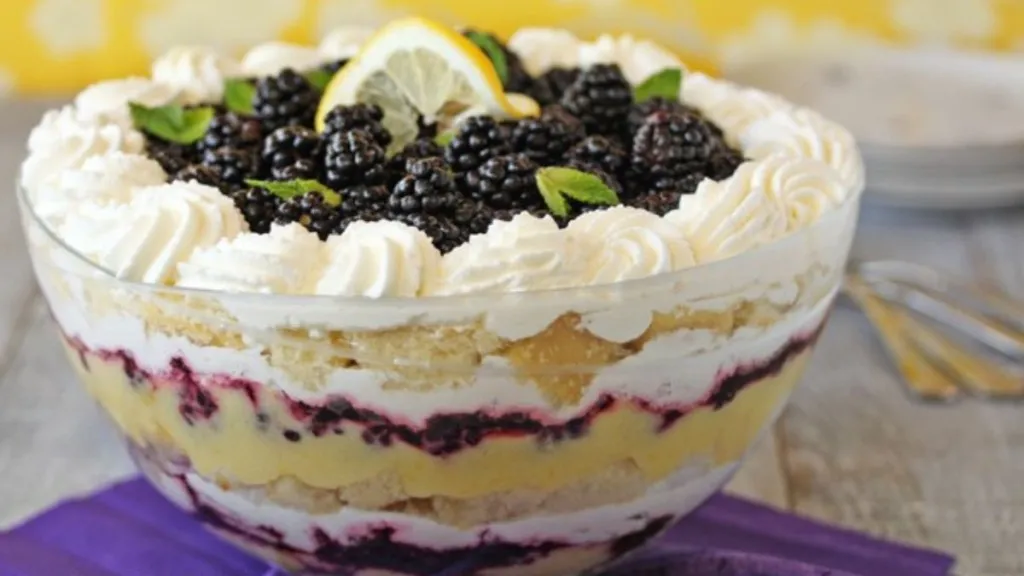 A trifle made of cake, whipped cream, blackberries and lemon.