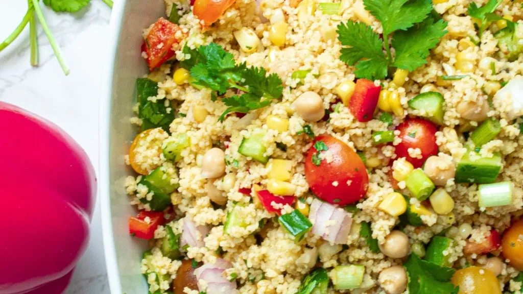 A bowl of vegan salad with couscous and corn.