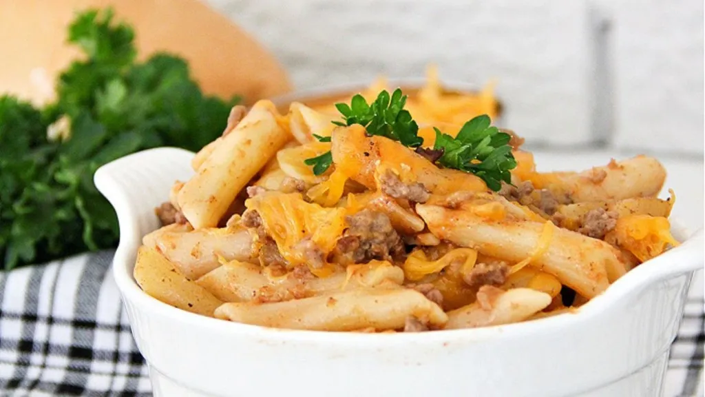 a bowl of pasta, hamburger and sauce.