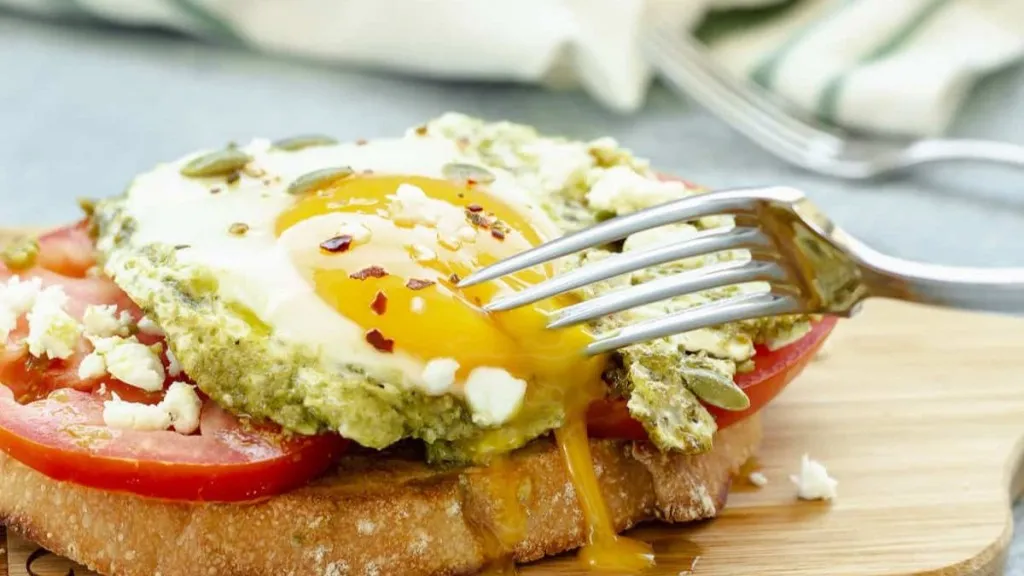 Toast topped with tomato and pesto eggs.