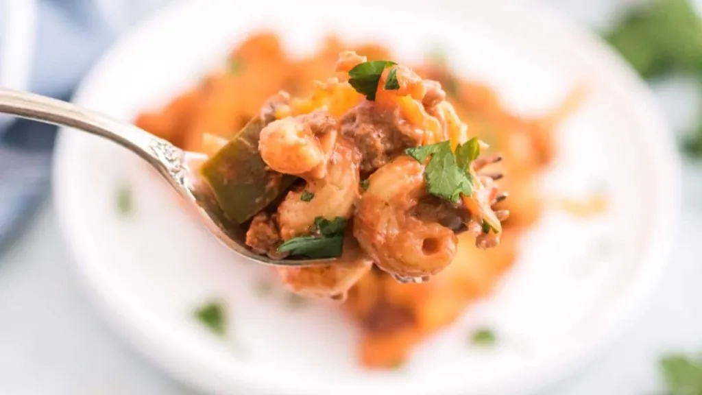 A fork of sloppy joe casserole with cheese and peppers.