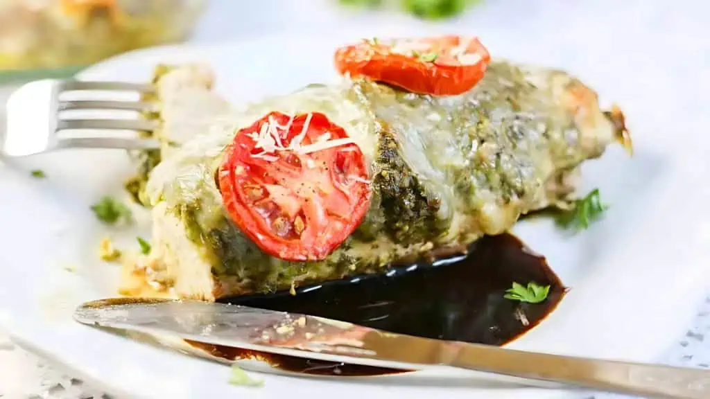 delicious and easy to make basil pesto chicken with sliced tomatoes and melted mozzarella