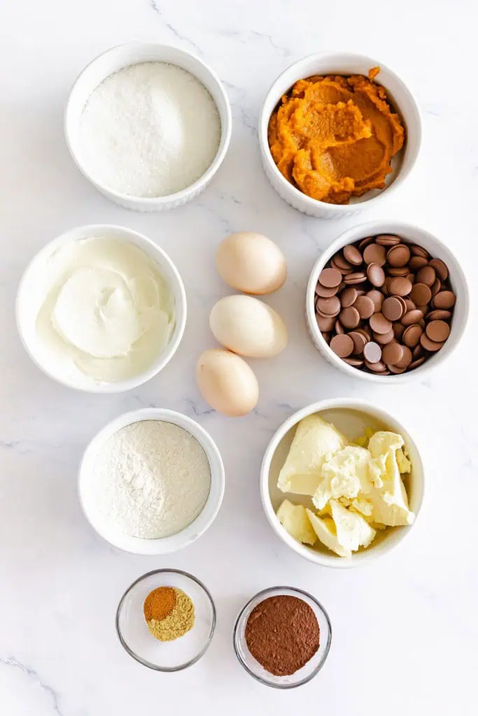 Ingredients for pumpkin cream cheese brownies on a marble countertop.
