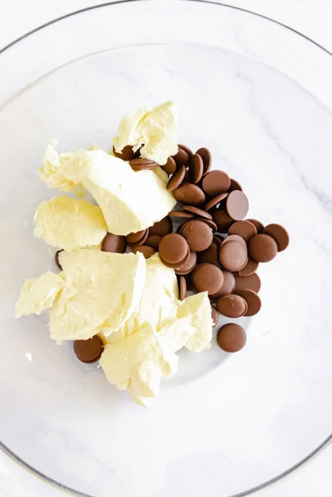 Glass mixing bowl with chocolate chips and butter.