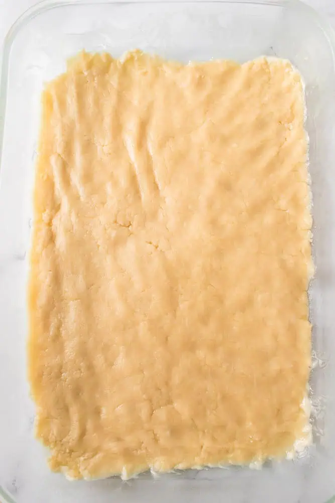 Pumpkin pie dessert bar crust spread evenly into the bottom of a prepared glass baking dish.