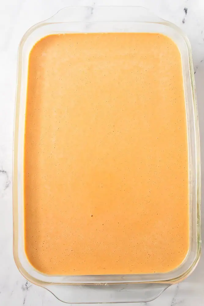 Pumpkin pie dessert bar filling poured into the prepared glass baking dish. 