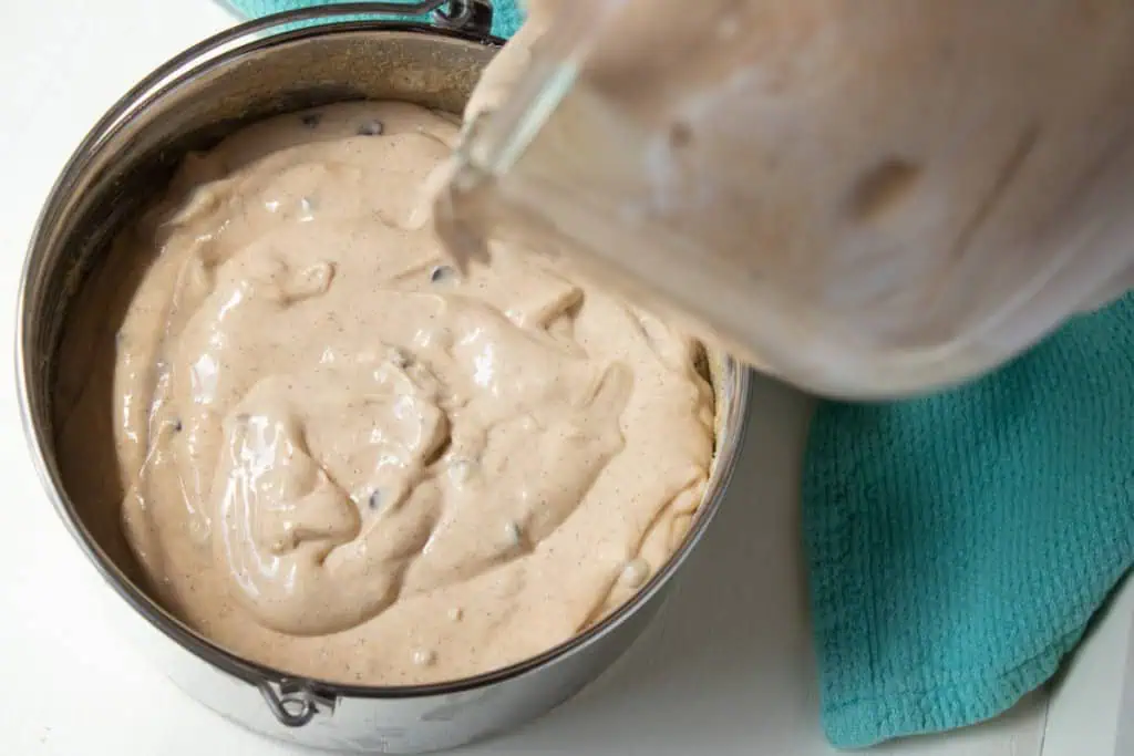 Pumpkin chocolate chip cheesecake filling poured into the cake pan with the chilled crust.