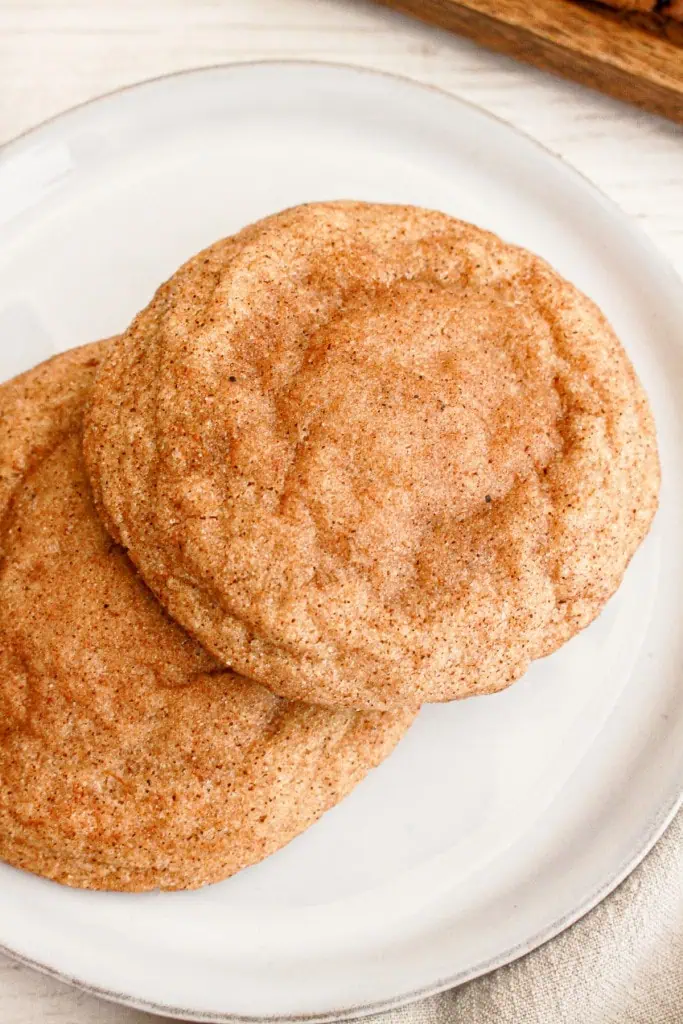 Two pumpkin cheesecake cookies on a white plate.