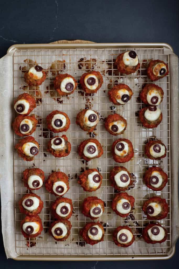 Large baking sheet with spooky eyeball meatballs.