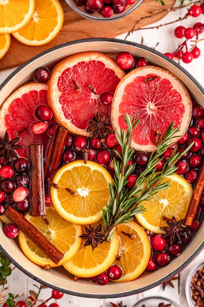 Close up of Christmas simmering pot with extra ingredients in the background.