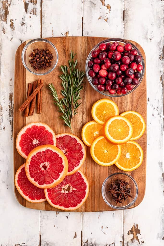 Ingredients for making Christmas Simmering Pot Jars on a wooden kitchen board. 