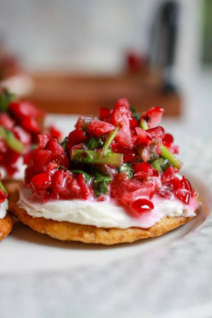 Close up of cranberry jalapeno salsa on a cracker with cream cheese.