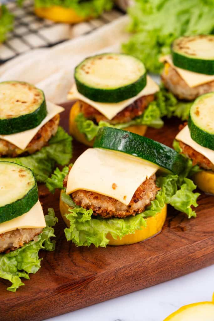 A fresh batch of zucchini slides on a wooden board.
