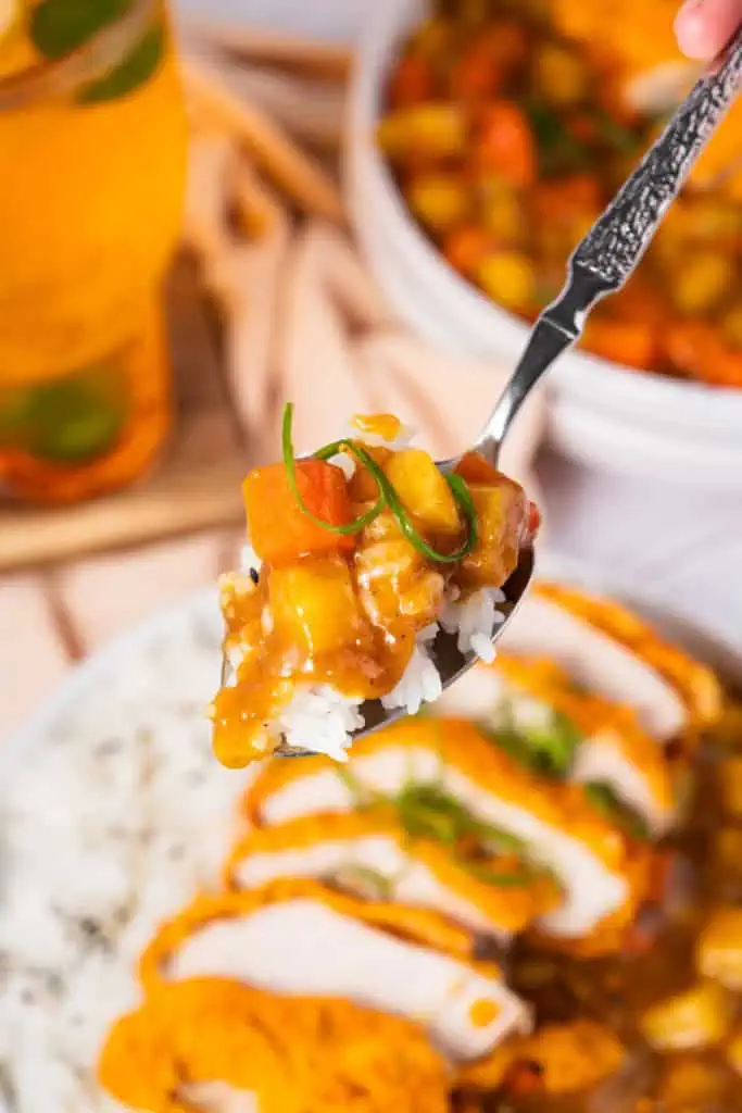 Close up of a forkful of Japanese Pork Katsu curry with the remainder of the dish below.