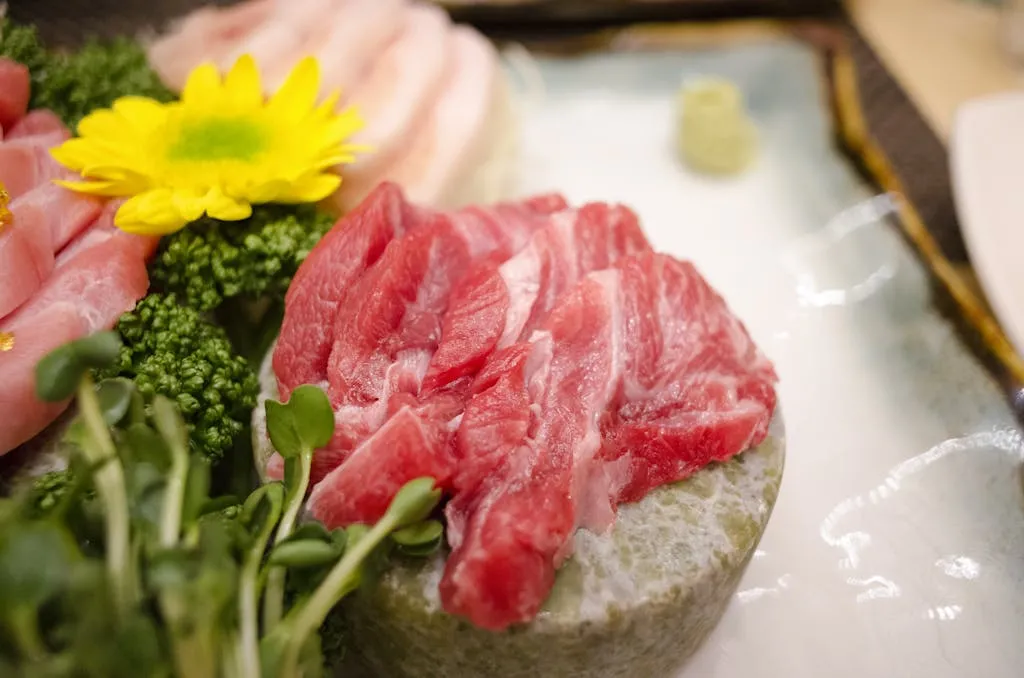 Close-up of a fresh sashimi platter featuring vibrant cuts of meat and colorful garnish, ready to serve.